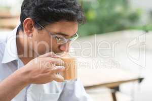 Indian businessman sipping a cup hot milk tea