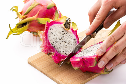 Hands Of A Chef Cutting A Dragonfruit In Half