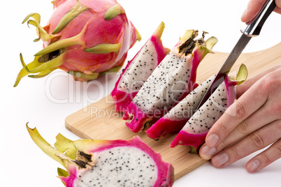 Cutting A Halved Pitaya Into Four Fruit Wedges