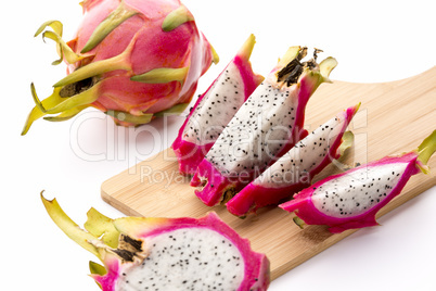 Four Fruit Wedges Of A Cut Pitaya On Cutting Board