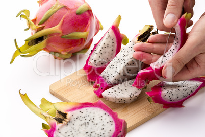 Hands Removing Pulp From A Pitaya Fruit Wedge
