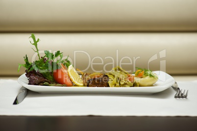 Aegean-style vegetables on white plate with cutlery