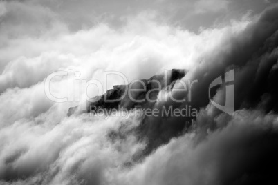 Black and white cliff appearing through clouds