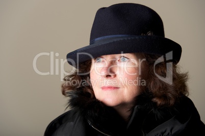 Brunette staring in black trilby and coat