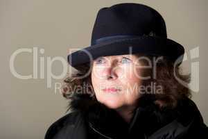 Brunette staring in black trilby and coat