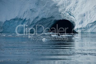 Cave in ice cliff in Arctic Ocean