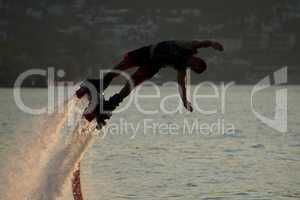 Close-up of Flyboarder diving into dusk sea