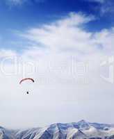 Parachutist silhouette of mountains in windy sky