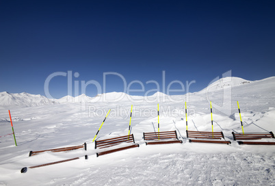 Ski slope and wooden benches in snow