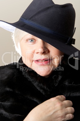 Close-up of white-haired woman in black hat