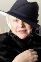 Close-up of white-haired woman in black hat
