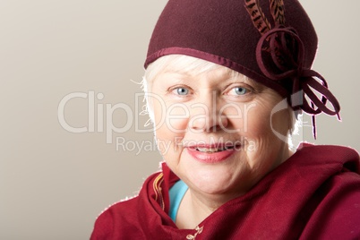 Close-up of white-haired woman in maroon hat