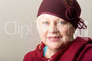 Close-up of white-haired woman in maroon hat