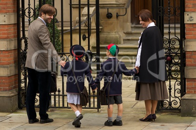 Family of four entering old school gates