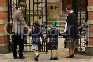 Family of four entering old school gates