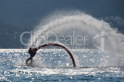 Flyboarder ankles entering water during semi-circular dive