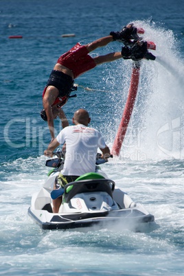 Flyboarder diving past man on Jet Ski