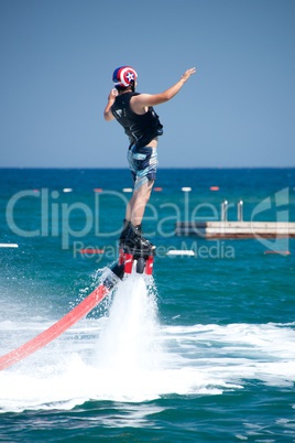 Flyboarder falling backwards next to swimming platform