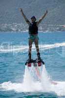 Flyboarder giving victory sign with both hands