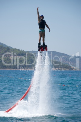 Flyboarder giving victory sign with one hand