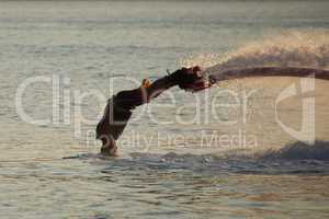 Flyboarder in dive with head touching water