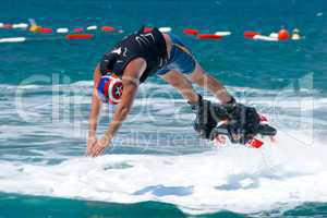 Flyboarder in helmet diving low into water