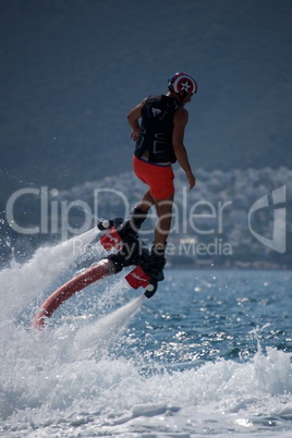 Flyboarder in helmet flying above bubbling whitewater