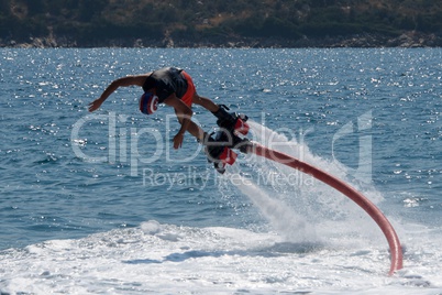 Flyboarder in pink shorts diving into whitewater