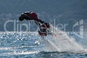 Flyboarder in pink shorts diving to left