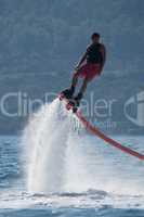 Flyboarder in pink shorts turning to right