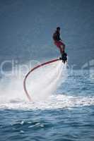 Flyboarder in pink shorts spiralling over spray