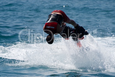 Flyboarder in red diving headfirst towards camera