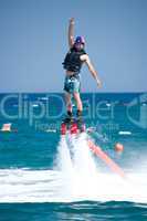 Flyboarder throwing arm up above his head
