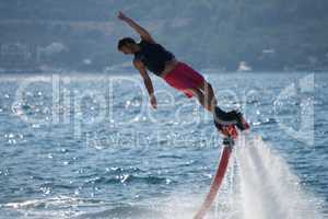 Flyboarder with arm raised about to dive