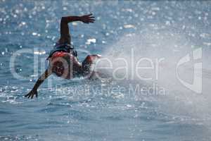 Flyboarder with outstretched arms low over water