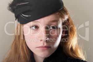 Redhead in a black hat looking sad