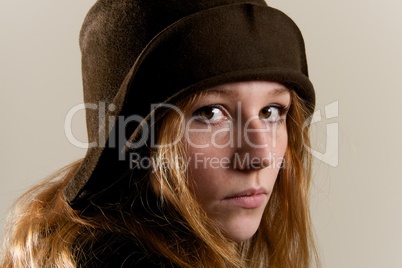Redhead in brown cloche hat looking serious