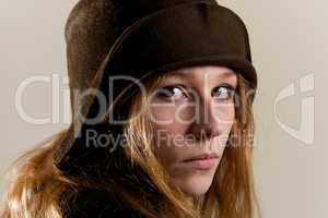 Redhead in brown cloche hat looking serious