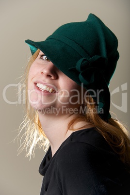 Redhead in green hat with head tilted