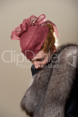 Redhead in red mesh hat looking down