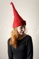 Redhead in red pointed hat turning head
