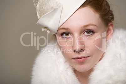 Redhead serious in a white felt hat and fur
