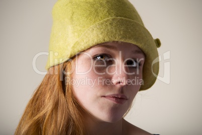 Redhead serious in a yellow felt hat