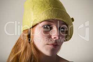 Redhead serious in a yellow felt hat