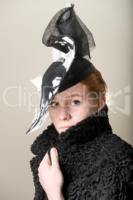 Redhead serious in black and white hat and black coat