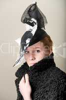 Redhead serious in black and white hat and black coat