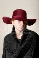Redhead serious in maroon hat and black coat