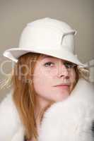 Redhead serious in white felt hat and fur