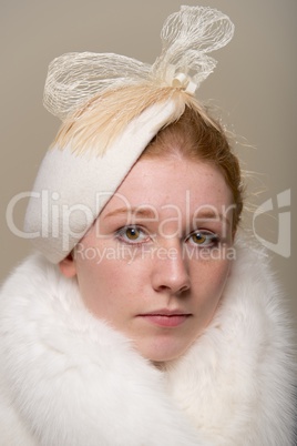 Redhead serious in white hat with bow and fur Redhead serious in white hat with bow and fur