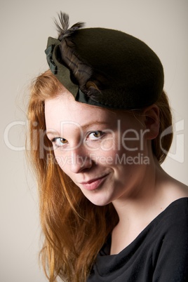 Redhead smiling cheekily in green feathered hat